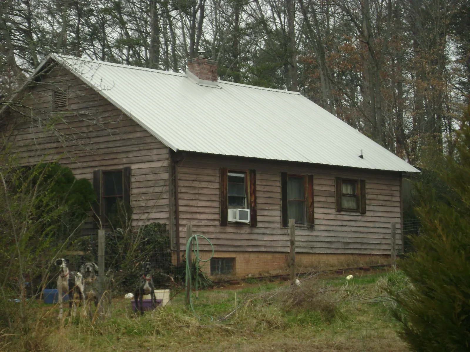 White metal roof on an old wood sided farmhouse, from a Metal Roof Installation job in Granville